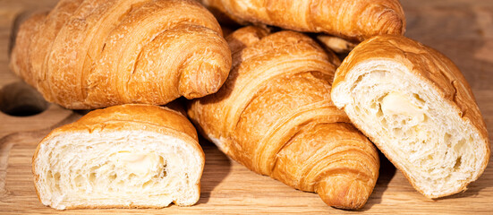 fresh croissants on wooden board on a dark background