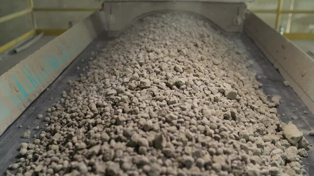 Close-up of bulk materials in a factory. Processing of raw additives in bulk at the plant. Crushed stone for addition to cement. Cement additives at the plant.