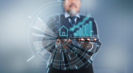 A businessman using digital tablet with house icon, data and business growth on  hologram.
Futuristic technology style, on blue background. 
