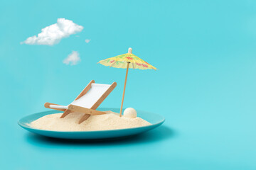 Tropical beach concept made of plate with sand, deck chair and sun umbrella. Creative summer...