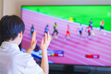 家でスポーツをテレビ観戦する若い女性のイメージ Wall Mural Show999
