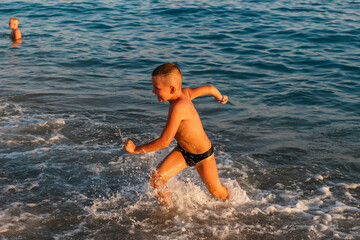 Seven-year-old tanned boy runs on water at sea