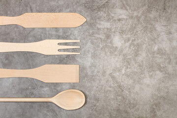 Varios utensilios de cocina de madera sobre un fondo gris rústico. Vista superior y de cerca. Copy...