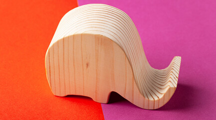 Elephant figurine carved from solid pine by hand jigsaw. On a multi-colored background