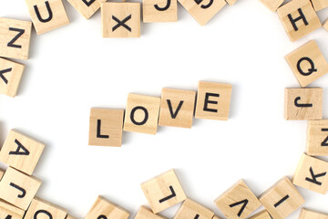 Top view, Love the alphabet on the wooden tile pieces scraped square. Isolated on white background