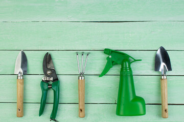 Composition with flowers and gardening tools on the wooden background with space for text. Top view.