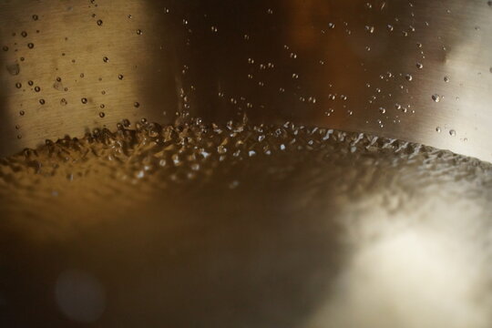 Water drops close up in tibetan singing bowl for sound healing therapy.