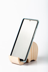 A figurine, an elephant phone stand, cut out of solid pine with a hand jigsaw. On a white background