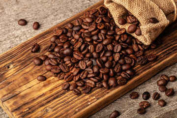 Roasted coffee beans on the old dark wooden background for wallpaper or decor