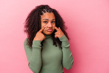 Young african american woman isolated on pink background crying, unhappy with something, agony and confusion concept.