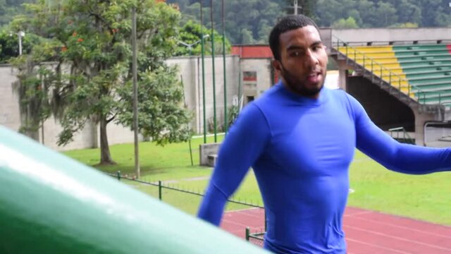 Hombre moreno con ropa de licra subiendo y bajando escalas en un estadio