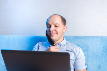 Man takes off mask at home in front of laptop. Safe online communication during a pandemic.