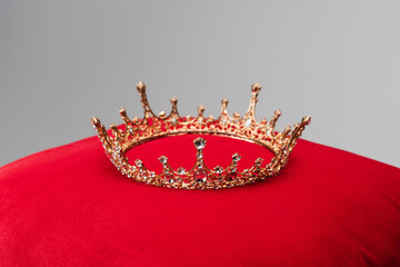 luxury crown on red velvet cushion isolated on grey