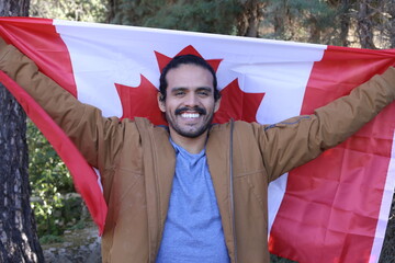 Proud ethnic man holding the Canadian flag