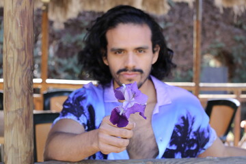 Handsome man holding purple flower