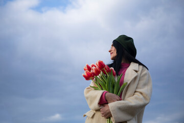 Woman tulips. Flowers. Sky background. Sensual. Mother day.