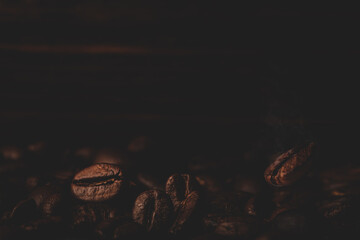 Roasted coffee beans on the old dark wooden background for wallpaper or decor