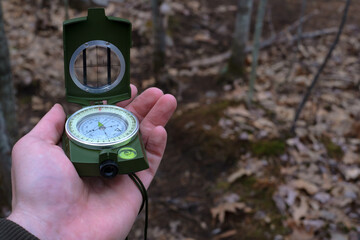 Naklejka premium Hand raising prismatic compass on a trail