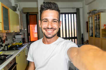 Fototapeta premium Handsome young man taking a selfie indoor - Smiling guy looking at camera 