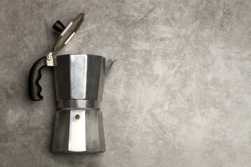 Cafetera Italiana plateada con la tapa levantada sobre un fondo gris rústico. Vista superior. Copy...