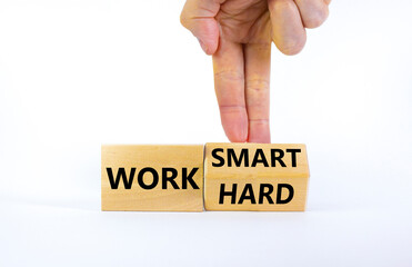 Work hard or smart symbol. Businessman turns wooden block and changes words 'work hard' to 'work smart'. Beautiful white background, copy space. Business and work hard or smart concept.