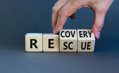 Recovery and rescue symbol. Businessman turns cubes and changes the word 'recovery' to 'rescue'. Beautiful grey background. Business and recovery - rescue concept. Copy space.