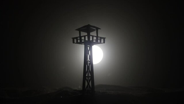 Creative artwork decoration. War concept. Silhouette of army watchtower at night. Selective focus