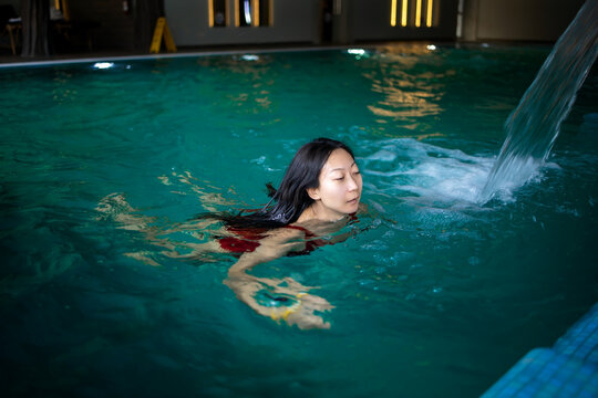 Asian Woman Swimming In Indoor Pool