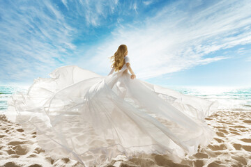 Woman on Beach in White Dress flying on Wind. Summer Vacation. Beach Sand Sea Sunshine Sky - 425830443