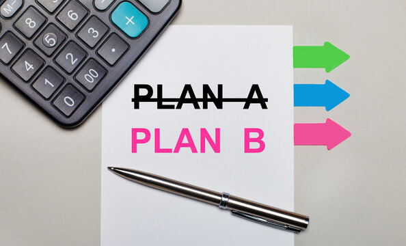On a light gray background, a calculator, a white sheet with the text PLAN B, a pen and bright multicolored stickers. View from above