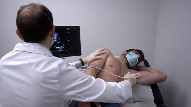 Doctor examining heart of patient with ultrasound equipment