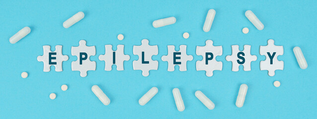 On a blue background, there are pills and puzzles with the inscription - EPILEPSY