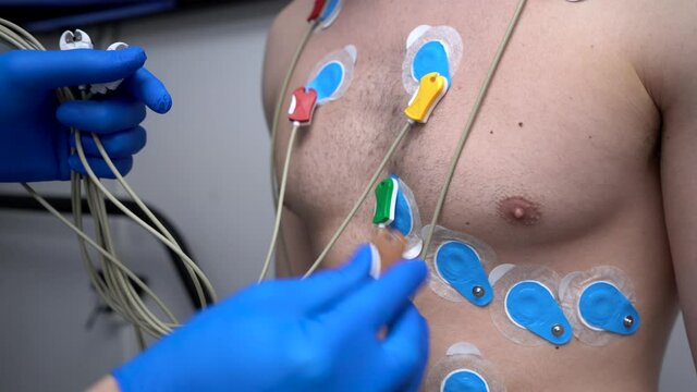 Crop doctor connecting electrodes to chest of patient for ECG