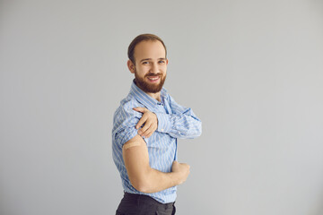 Portrait of smiling young man after receiving flu or coronavirus vaccine. Happy office worker on...