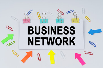 On the table there are paper clips and directional arrows, a sign that says - Business Network