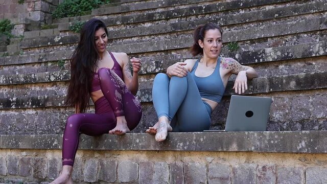 Content diverse women having yoga lesson via laptop