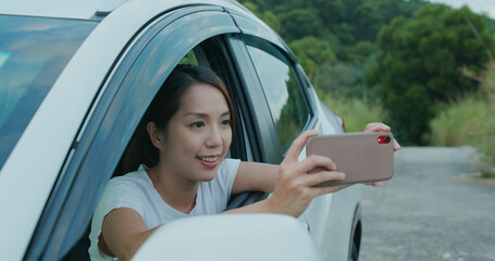 Travel woman use cellphone to take photo and sit inside car