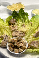 Homemade Caesar Salad with romanine, cheese, croutons, chicken, lemon and sauce