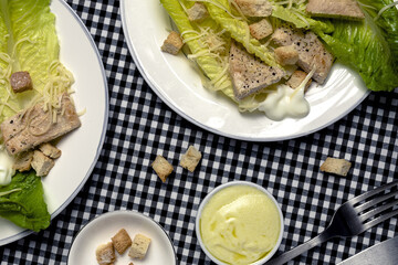 Homemade Caesar Salad with romanine, cheese, croutons, chicken, lemon and sauce