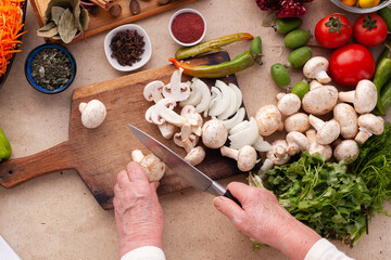 Sliced mushrooms and onion on a wooden table with vegetables for cooking a vegetarian meal. Healthy eating without meat.