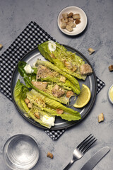 Homemade Caesar Salad with romanine, cheese, croutons, chicken, lemon and sauce