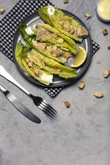 Homemade Caesar Salad with romanine, cheese, croutons, chicken, lemon and sauce