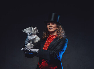 Caucasian female artist dressed in costume with top hat and doves