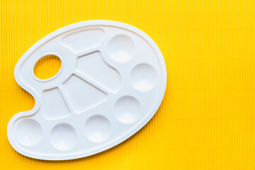 palette for paints, white palette for paints on a yellow background 