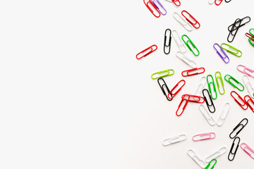 stationery, colored paper clips on a white background
