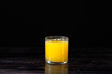 glass of fresh orange juice on a vintage wooden background