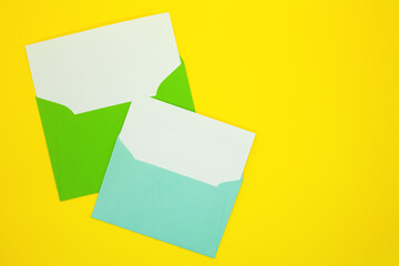 Two envelopes with blank white cards. Yellow background.  Mockup with envelope and blank card. Space for text.