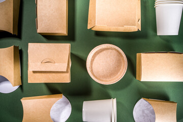 Cardboard fast food and drink packaging concept. Set of various takeaway foods containers on green background, Eco-friendly