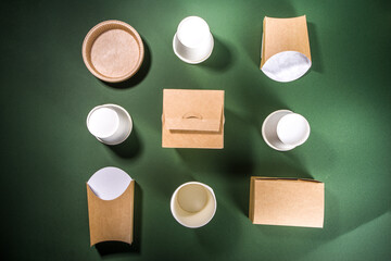 Cardboard fast food and drink packaging concept. Set of various takeaway foods containers on green background, Eco-friendly