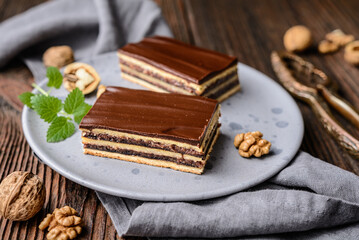 Cocoa and walnut cake with plum jam, topped with chocolate frosting